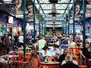 A photo of Prestom Market with customers eating at tables in the foreground